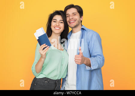 Amare giovane pronto per la marcia, mostrando passaporto e il pollice in alto Foto Stock