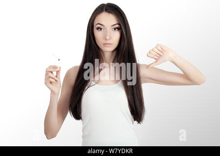 Sano giovane donna rifiuta di prendere la sigaretta dal pacchetto. Ritratto di bella donna che mostra un segno di stop con la mano per sigarette. Smettere di fumare Concept Foto Stock