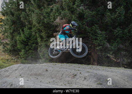 Mtb biker saltando su un polveroso jump Foto Stock