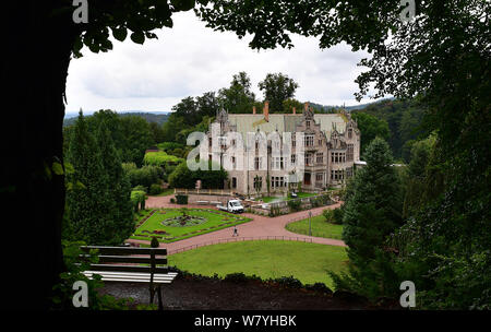 07 agosto 2019, Turingia, Bad Liebenstein: un visitatore passeggiate attraverso il parco passato Altenstein Castello. La residenza estiva dei duchi di Saxony-Meiningen con il suo castello del XIX secolo è attualmente sottoposto ad ampi lavori di ristrutturazione dopo un incendio nel 1982 distrusse l'interno. Altenstein è una stazione del #Kultursommertour 2019 della Turingia del Ministro della Cultura. Foto: Martin Schutt/dpa-Zentralbild/dpa Foto Stock