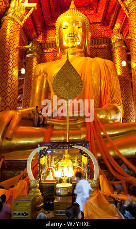 Cerimonia che ornano statua dorata di Buddha (chiamando la terra a testimoniare la postura) in giallo infissi, Wat Phanan Choeng, Ayutthaya. Thailandia, settembre 2014. Foto Stock