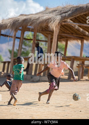 Ragazze e ragazzi che giocano a calcio, Anjaha comunitaria di conservazione Sito, vicino Ambalvao, Madagascar. Novembre 2014. Foto Stock