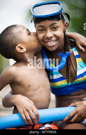 Ragazzo dando la sua sorella un bacio sulla guancia Foto Stock