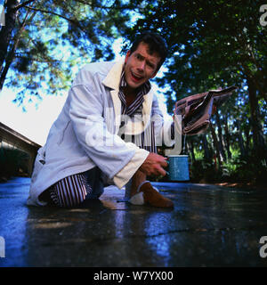 Lavorando sul suo sprinkler e ottenere schizzato in faccia Foto Stock