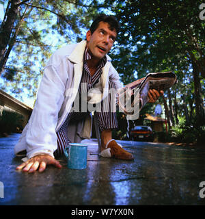 Lavorando sul suo sprinkler e ottenere schizzato in faccia Foto Stock