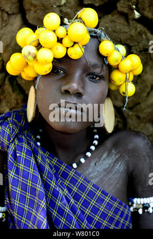 Mursi ragazza con il suo tradizionale copricapo di frutta, tribù dei Mursi. Parco Nazionale di Mago. Etiopia, Novembre 2014 Foto Stock