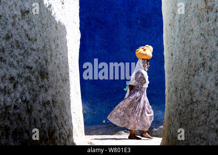 Le donne a piedi attraverso il colorato strette strade di Harar, un importante città santa nella fede islamica, Sito Patrimonio Mondiale dell'UNESCO. Etiopia, Novembre 2014 Foto Stock