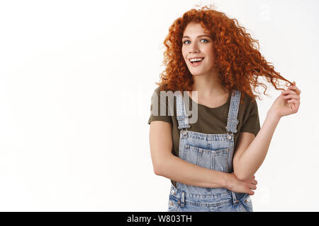 Fiducioso abilitate bella redhead, curly-haired girl, bracci trasversali e sorridente sicuri di sé alla fotocamera, conoscere il suo lavoro, dando professional vibes, s Foto Stock