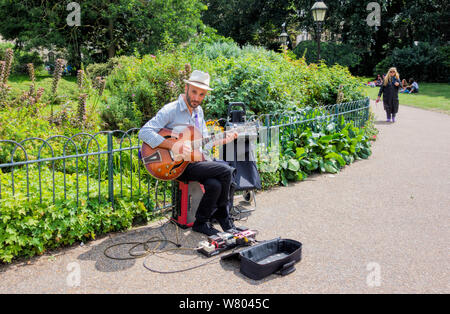 Busker suonando la chitarra nei giardini del Padiglione di Brighton Brighton Regno Unito Foto Stock