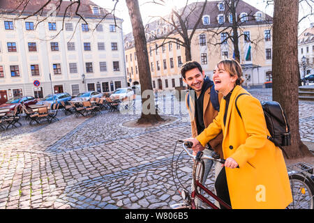 Giovani latino-uomo cammina vicino a donna Bicicletta Equitazione Foto Stock