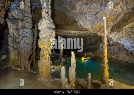 L uomo nella piccola barca rigida gonfiabile, Croce grotta (Krizna jama) sotto il monte Croce, Verde Carso, Slovenia, ottobre 2014. Foto Stock