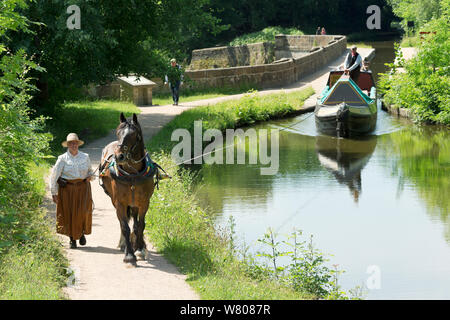 Sue Day, in un abito Vittoriano, le matasse con il suo progetto di cavallo, Maria, un 1814 narrowboat in legno, sui Navigli, vicino Marple, Metropolitan Borough of Stockport, Greater Manchester, Inghilterra. Luglio 2015. Foto Stock