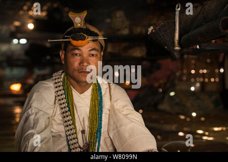 Nyshi uomo dentro Nyshi casa lunga, Nyshi tribù, Arunachal Pradesh.nord est dell India, novembre 2014. Foto Stock