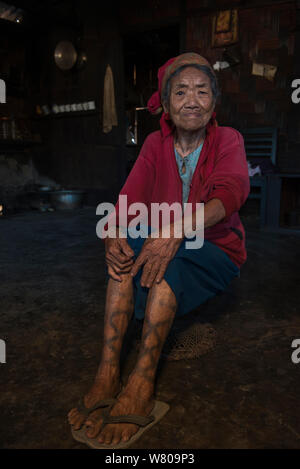 Ritratto di anziani Ao Naga donna con la gamba di tatuaggi. Ao Naga headhunting tribù. Mokokchung distretto. Il Nagaland, nord-est dell India, ottobre 2014. Foto Stock