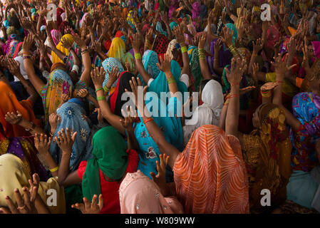 Le donne con le mani alzate al raduno religioso, Bateshwar Village, Distretto di Agra, Uttar Pradesh, India, ottobre 2014. Foto Stock