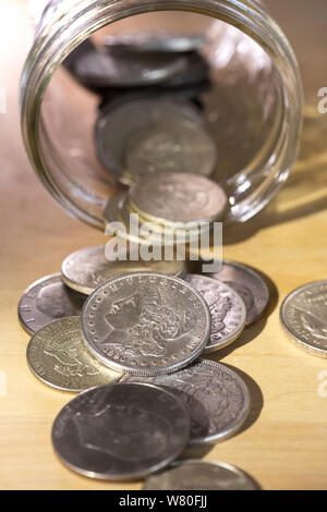 Vintage Silver Dollar monete fuoriuscita da un vaso di vetro, STATI UNITI D'AMERICA Foto Stock