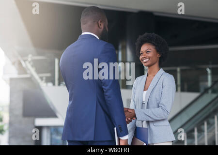 Il boss africana di handshaking dipendente femmina congratularmi con lei con la promozione Foto Stock
