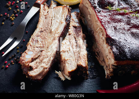 Close-up di giamaicano jerk arrosto di maiale con pancetta croccante di carbonizzazione della pelle, orizzontale vista da sopra Foto Stock