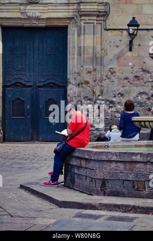 Barcellona, Spagna; 26 Settembre 2017: Persona la lettura di un libro al 'Felip Neri' Plaza nel quartiere Gotico di Barcellona Foto Stock