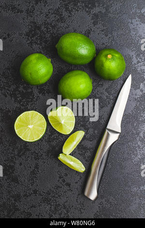 Il verde fettine di lime sulla tavola nera. Foto Stock