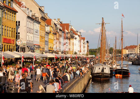 I viaggi in Europa; barche, gli edifici colorati e la folla di persone su un soleggiato serata estiva, Nyhavn Copenhagen DANIMARCA Europa Foto Stock