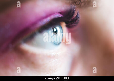 Aprire gli occhi blu con rosa ombretto e mascara closeup. Messa a fuoco selettiva. Foto Stock