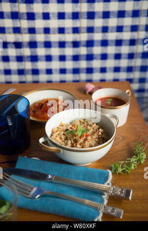 Pomodoro italiano zuppa di riso marrone risotto papaia dessert piatti di porcellana posate in argento biancheria blu igienico. Rio de Janeiro, Brasile. Durante l'anno 2019. Foto Stock