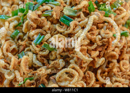 Pila di fritte o cuocere la carne di maiale snack, cotenna di maiale, carne di maiale di graffiare o cotiche sul vassoio in un mercato. Foto Stock