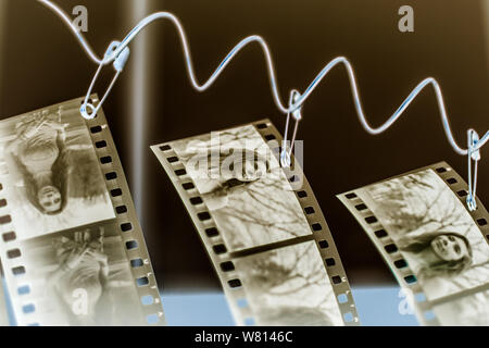Spazzato giù con una soluzione di alcol strofinante, strisce di negativi pellicola appendono ad asciugare, con le immagini negative invertite in Photoshop. Foto Stock