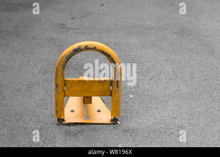 Barriera di parcheggio manuale in metallo rosso con blocco. Dispositivo di  blocco della posizione di parcheggio. Barriera di parcheggio installata.  Una barriera pieghevole impedisce il vehi Foto stock - Alamy