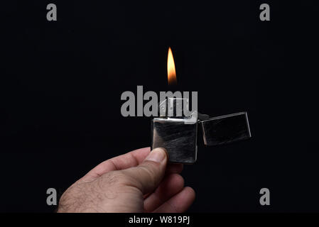 Azienda accendisigari illuminato su sfondo nero Foto Stock