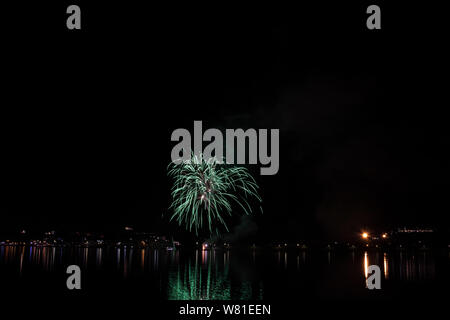 Bacoli, Napoli, 6 agosto 2019. I fuochi d'artificio dipingono il cielo in vari colori e sono riflesse nel lago Miseno, creando un panorama mozzafiato. Foto Stock