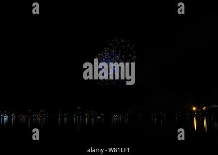 Bacoli, Napoli, 6 agosto 2019. I fuochi d'artificio dipingono il cielo in vari colori e sono riflesse nel lago Miseno, creando un panorama mozzafiato. Foto Stock