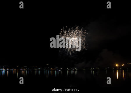Bacoli, Napoli, 6 agosto 2019. I fuochi d'artificio dipingono il cielo in vari colori e sono riflesse nel lago Miseno, creando un panorama mozzafiato. Foto Stock