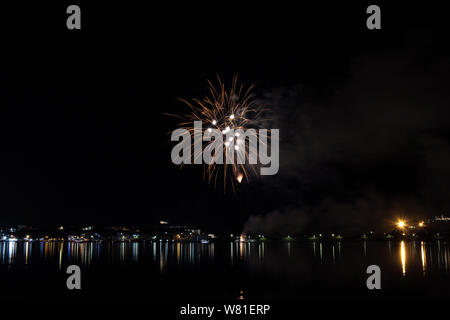 Bacoli, Napoli, 6 agosto 2019. I fuochi d'artificio dipingono il cielo in vari colori e sono riflesse nel lago Miseno, creando un panorama mozzafiato. Foto Stock