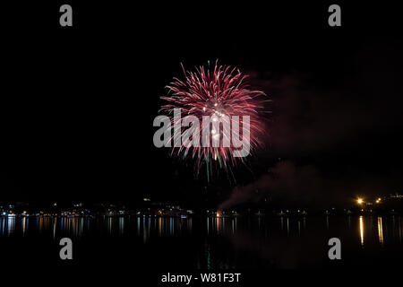 Bacoli, Napoli, 6 agosto 2019. I fuochi d'artificio dipingono il cielo in vari colori e sono riflesse nel lago Miseno, creando un panorama mozzafiato. Foto Stock