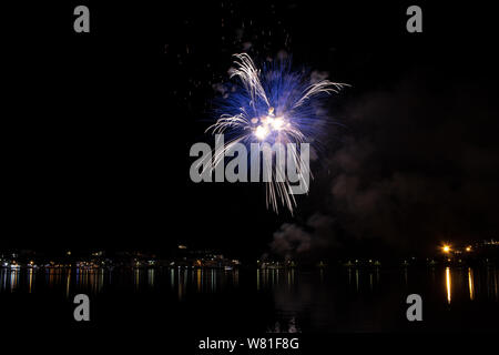 Bacoli, Napoli, 6 agosto 2019. I fuochi d'artificio dipingono il cielo in vari colori e sono riflesse nel lago Miseno, creando un panorama mozzafiato. Foto Stock
