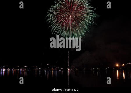Bacoli, Napoli, 6 agosto 2019. I fuochi d'artificio dipingono il cielo in vari colori e sono riflesse nel lago Miseno, creando un panorama mozzafiato. Foto Stock