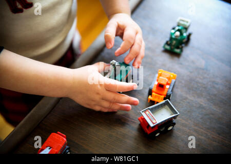 Giovane ragazzo giocando con i camion giocattolo Foto Stock