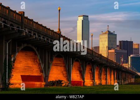 Bellissima e la vista unica di Dallas, Texas skyline da un prato erboso vicino a Sud di Houston Street Bridge durante il tramonto. Foto Stock