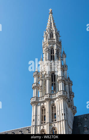 Bruxelles, Belgio - 22 Giugno 2019: Closeup di pietra grigia guglia di city hall sulla Grand Place contro il cielo blu. Golden Saint Michael statua in cima. Foto Stock