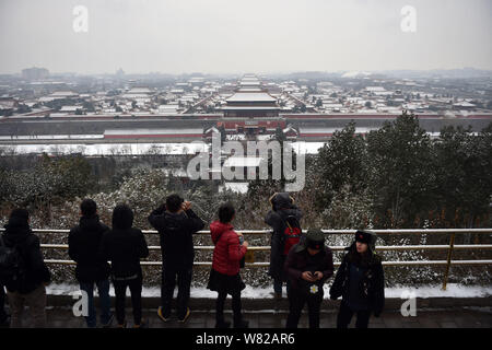 I turisti viste Palace Museum, conosciuta anche come la Città Proibita, dal Parco Jingshan nella neve a Pechino in Cina, 21 febbraio 2017. Foto Stock