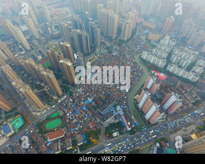 --FILE -- Una veduta aerea di una baraccopoli con vecchie case accanto a grappoli di alto e moderno appartamento residenziale fabbricati in Cina a Shanghai, 7 Dece Foto Stock