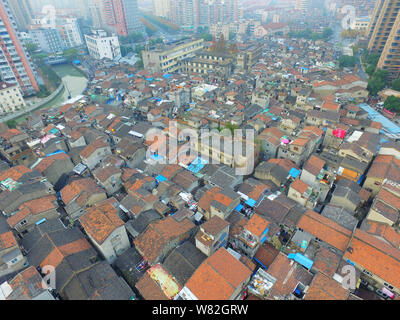 --FILE -- Una veduta aerea di una baraccopoli con vecchie case accanto a grappoli di alto e moderno appartamento residenziale fabbricati in Cina a Shanghai, 7 Dece Foto Stock