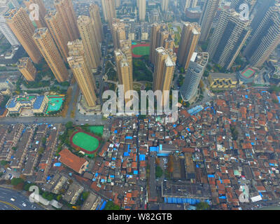 --FILE -- Una veduta aerea di una baraccopoli con vecchie case accanto a grappoli di alto e moderno appartamento residenziale fabbricati in Cina a Shanghai, 7 Dece Foto Stock