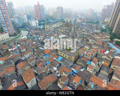 --FILE -- Una veduta aerea di una baraccopoli con vecchie case accanto a grappoli di alto e moderno appartamento residenziale fabbricati in Cina a Shanghai, 7 Dece Foto Stock