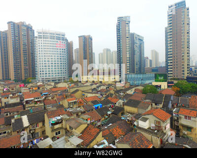 --FILE -- Una veduta aerea di una baraccopoli con vecchie case accanto a grappoli di alto e moderno appartamento residenziale fabbricati in Cina a Shanghai, 7 Dece Foto Stock