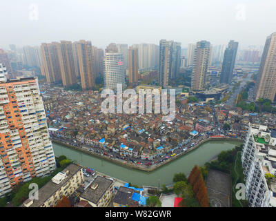 --FILE -- Una veduta aerea di una baraccopoli con vecchie case accanto a grappoli di alto e moderno appartamento residenziale fabbricati in Cina a Shanghai, 7 Dece Foto Stock