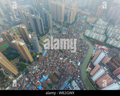 --FILE -- Una veduta aerea di una baraccopoli con vecchie case accanto a grappoli di alto e moderno appartamento residenziale fabbricati in Cina a Shanghai, 7 Dece Foto Stock