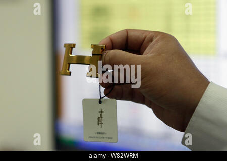 --FILE--cinese esaminatore identifica un Hermes logo in Asia la più grande di oggetti di lusso nel centro di autenticazione a Pechino in Cina, 14 giugno 2016. Le persone hanno Foto Stock